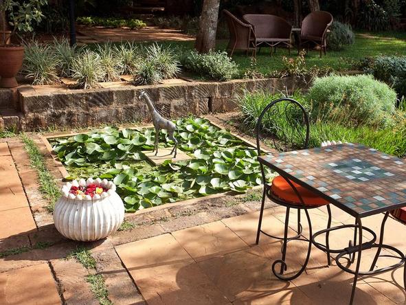 The Giraffe Manor - Sip your morning coffee beside the pond in the garden.
