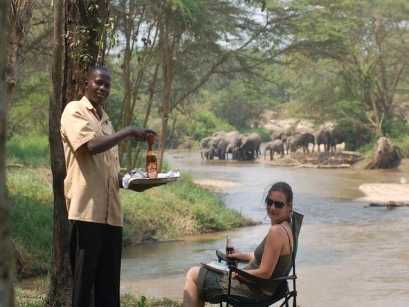Ishasha Wilderness Camp - guest + elephant crossing river