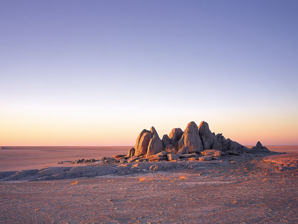 Enigmatic rock islands rise out of pancake-flat salt pans - the Kalahari is a place of surprises.
